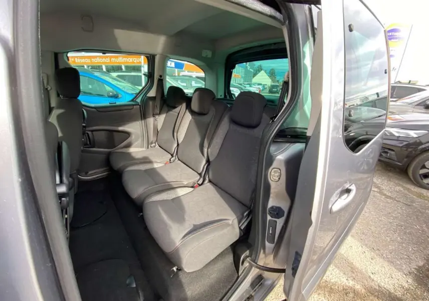 Vue intérieure côté droit du Peugeot Partner gris Artense, montrant la banquette arrière 2/3-1/3 et la porte coulissante ouverte.