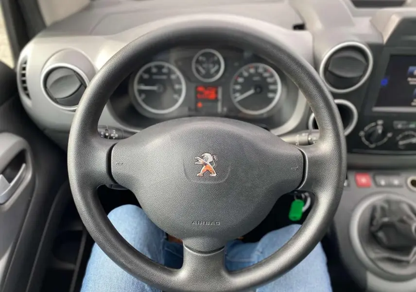 Vue rapprochée du volant noir de la Peugeot Partner 2017 avec tableau de bord et levier de vitesses manuelle visibles.