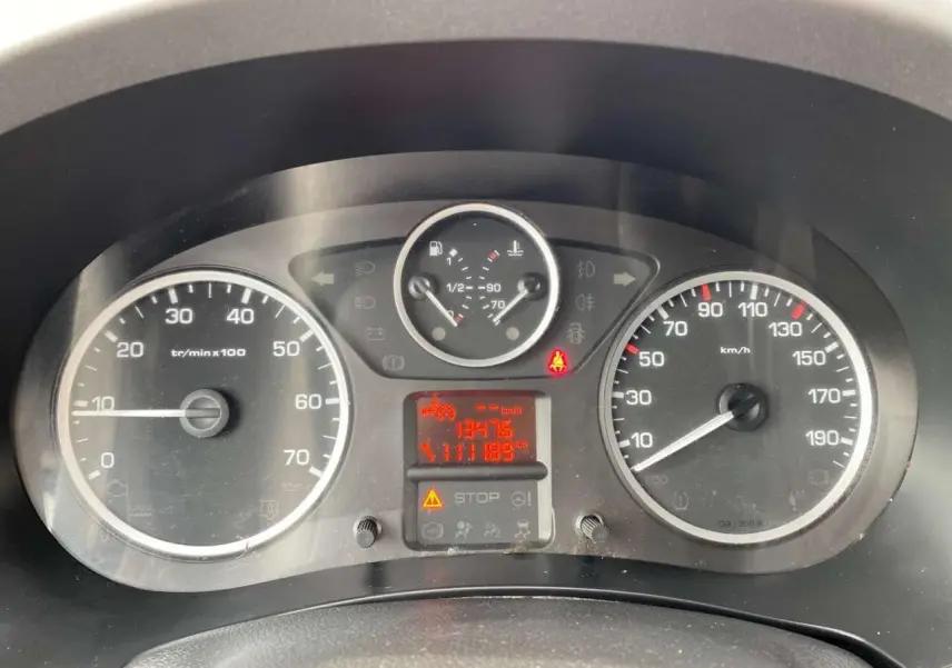 Vue rapprochée du tableau de bord du Peugeot Partner gris Artense 2017, affichant compteurs et témoins lumineux.