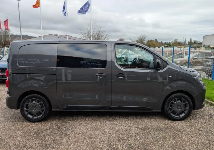 Profil côté droit d'un utilitaire Citroën Jumpy gris 2025 avec portes coulissantes et vitres teintées.