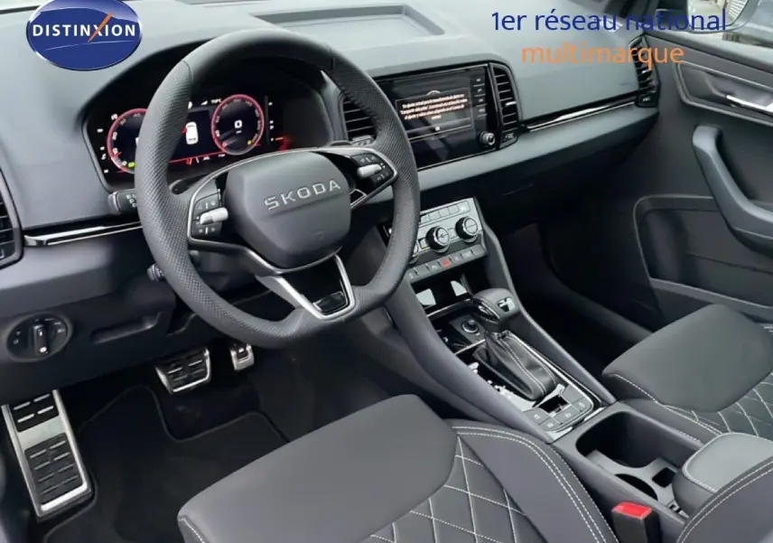 Intérieur noir de la Skoda Karoq 2025 vu côté conducteur, volant multifonction et console centrale avec boîte auto.