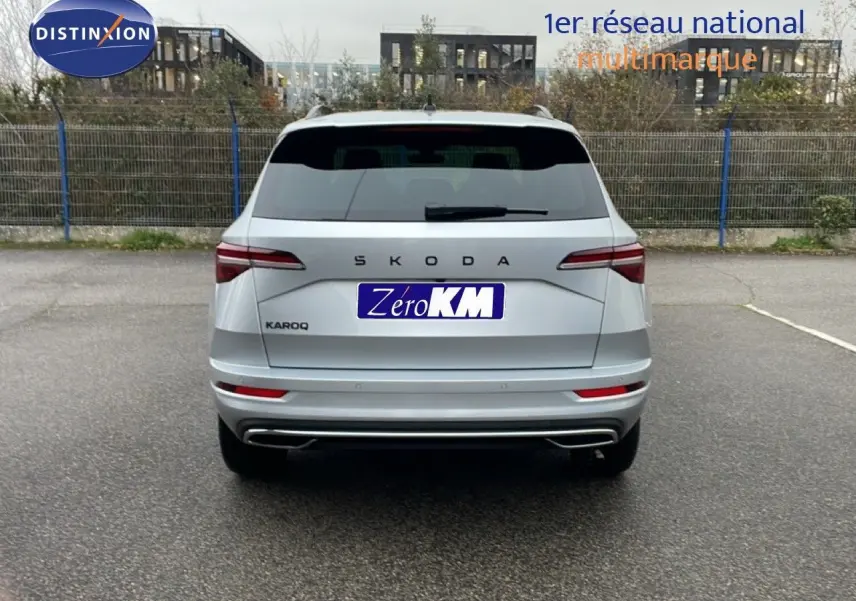 Vue arrière d'un Skoda Karoq gris argent métal 2025 avec feux LED et double sortie d'échappement intégrée.