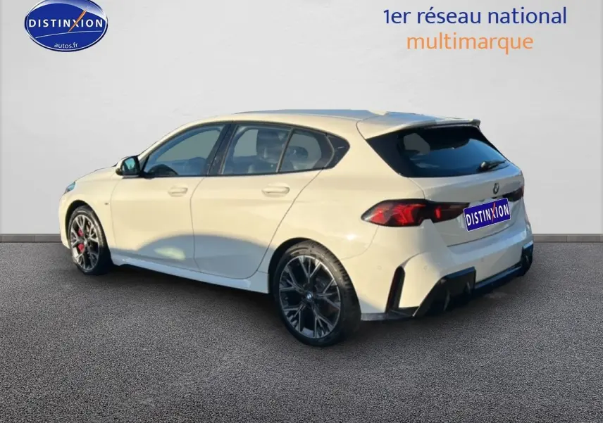 BMW Série 1 blanche alpin vue 3/4 arrière droit, avec jantes 18 pouces bicolores et becquet sportif M Sport Pro.