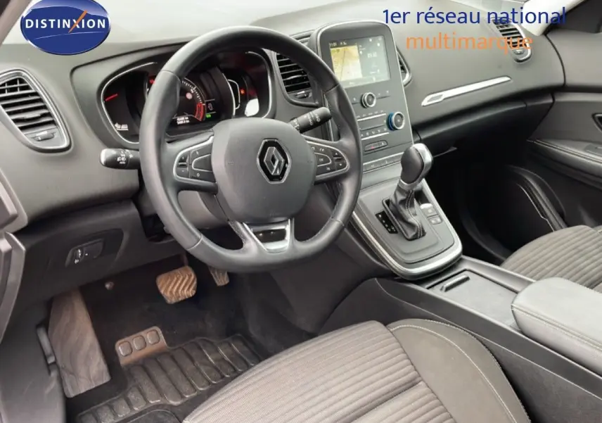 Intérieur noir du Renault Grand Scenic 2022, vue du poste de conduite avec volant multifonction et console centrale.