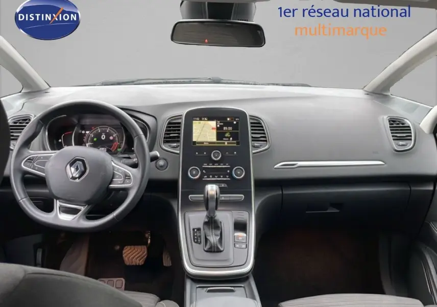 Vue intérieure avant du tableau de bord et volant noir du Renault Grand Scenic 2022 avec écran central tactile et levier de boîte automatique.