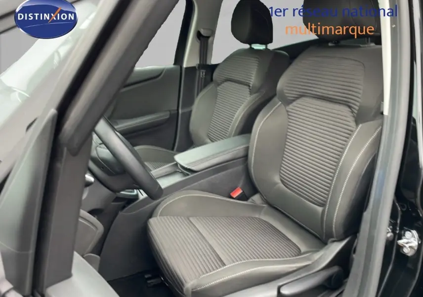 Vue intérieure côté conducteur du Renault Grand Scenic noir étoile métal, mettant en valeur les sièges avant en tissu et cuir.