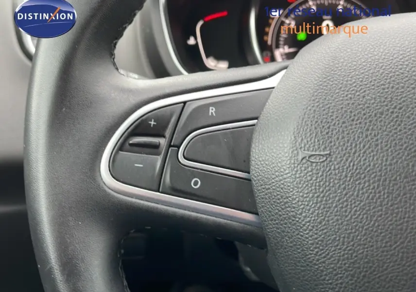 Gros plan sur le volant en cuir noir du Renault Grand Scenic 2022, avec commandes intégrées visibles à gauche.