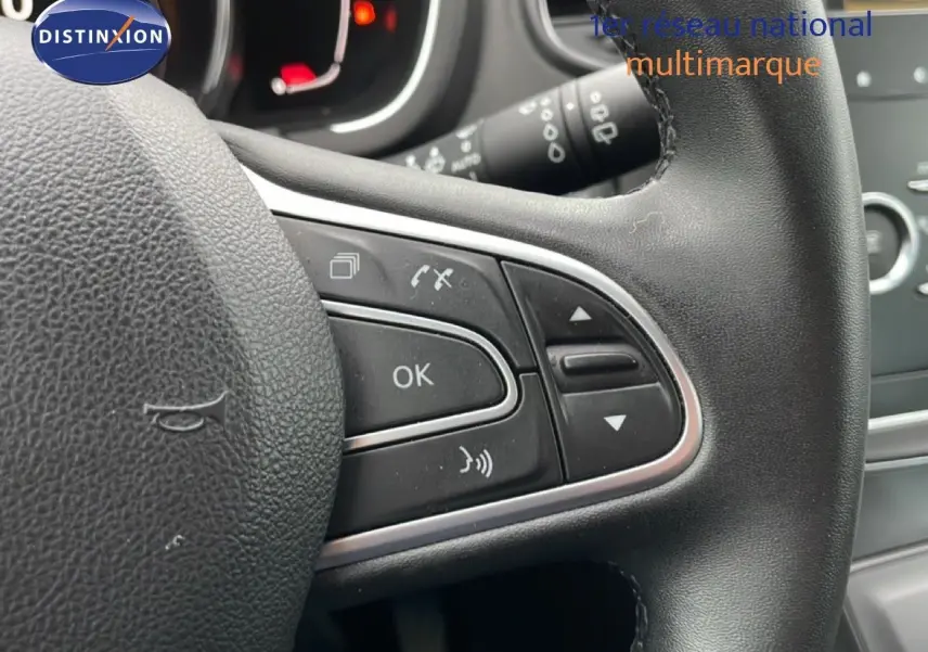 Gros plan sur le volant noir multifonction du Renault Grand Scenic 2022, avec commandes intégrées et finition cuir.