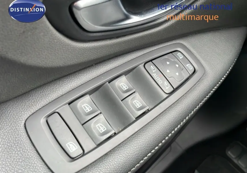 Gros plan sur les commandes de lève-vitres et rétroviseurs côté conducteur d’un Renault Grand Scenic noir étoile métal.