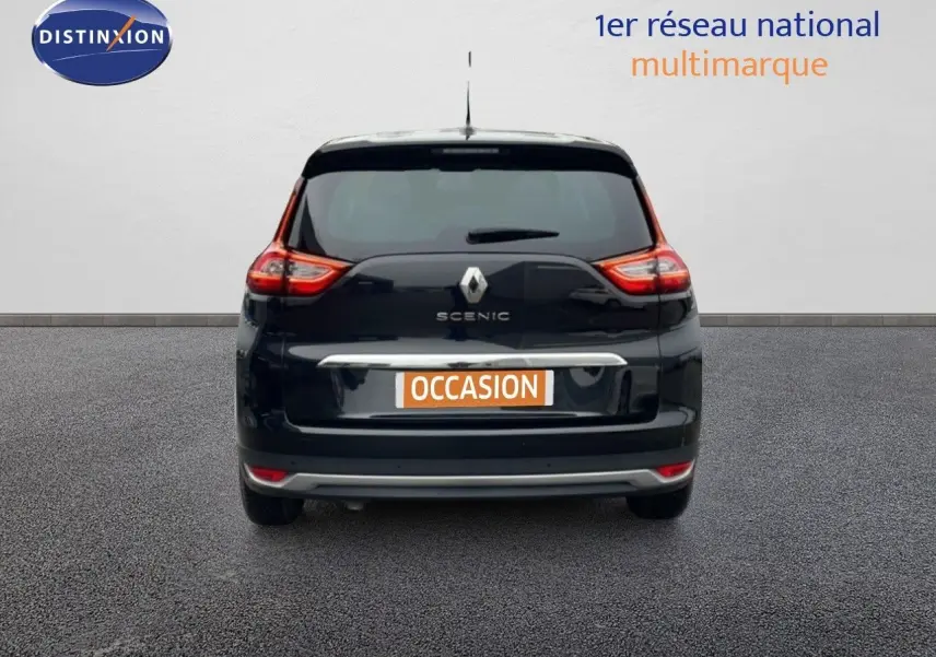 Vue arrière d'une Renault Grand Scenic noir étoile métal 2022 avec feux arrière allumés sur fond neutre.