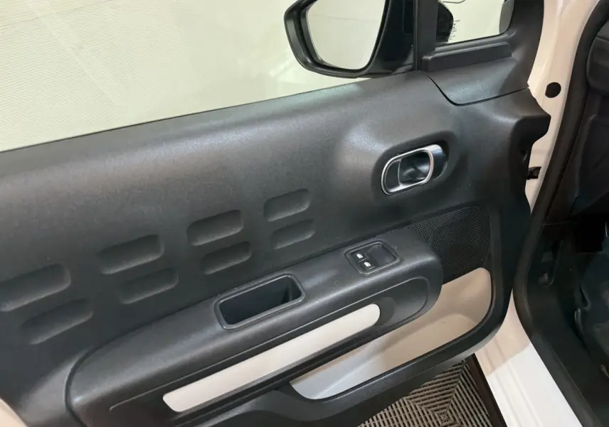 Vue rapprochée de la porte avant droite noire et blanche du Citroën C3 BlueHDi 100 Feel 2021 avec commandes de vitres électriques.