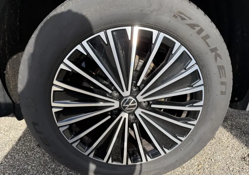 Gros plan sur la jante alliage noir et argent de 18 pouces du Volkswagen Tiguan blanc, avec logo VW central.