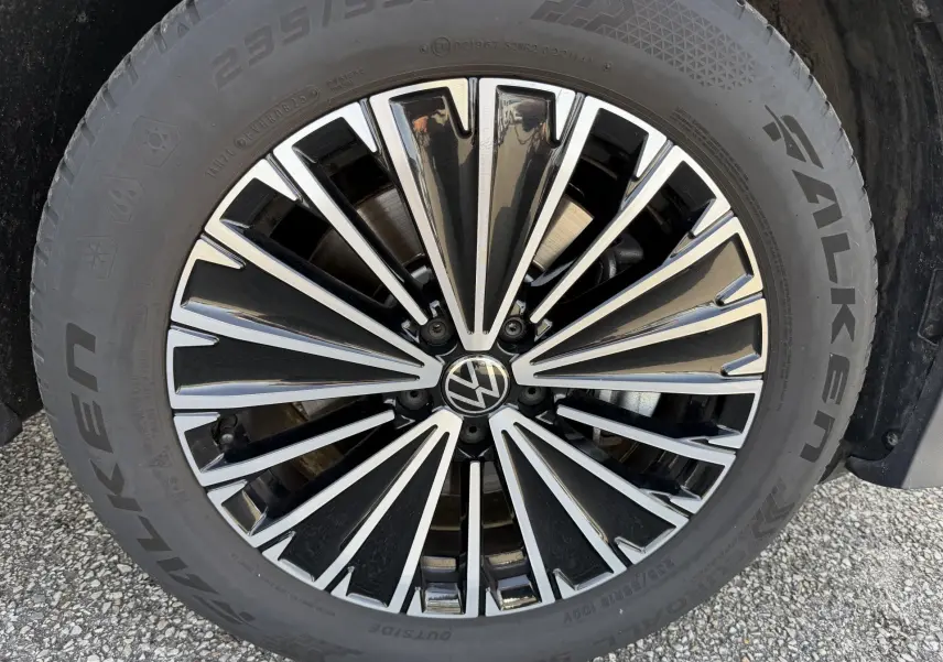 Gros plan sur la jante alliage noir brillant Napoli 18 pouces du Volkswagen Tiguan blanc, avec pneu Falken visible.