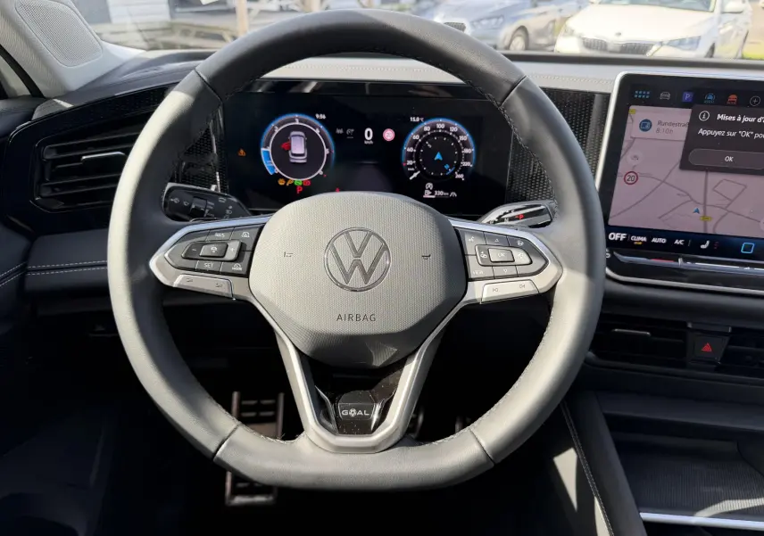 Vue rapprochée du volant multifonction en cuir noir du Volkswagen Tiguan 2025 avec tableau de bord numérique et écran tactile.
