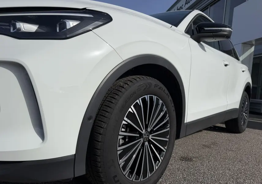 Vue de profil avant droit du Volkswagen Tiguan blanc 2025, mettant en valeur la jante alliage noire brillante Napoli.