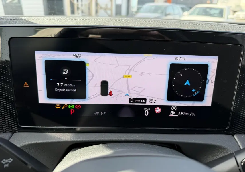 Affichage numérique du tableau de bord du Volkswagen Tiguan blanc, vue frontale centrée sur l'écran de navigation et d'instruments.