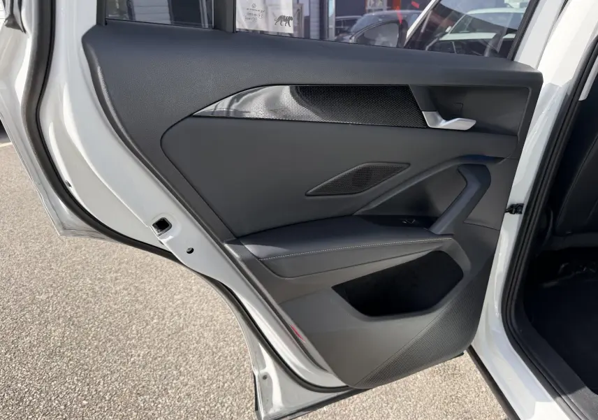 Vue intérieure de la porte arrière gauche blanche du Volkswagen Tiguan 2025 avec garniture noire et insert décoratif.