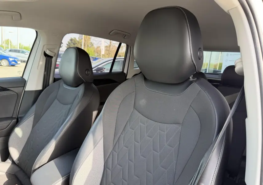 Gros plan sur les sièges avant en tissu et cuir noir du Volkswagen Tiguan 2025, vue côté droit depuis l'intérieur.