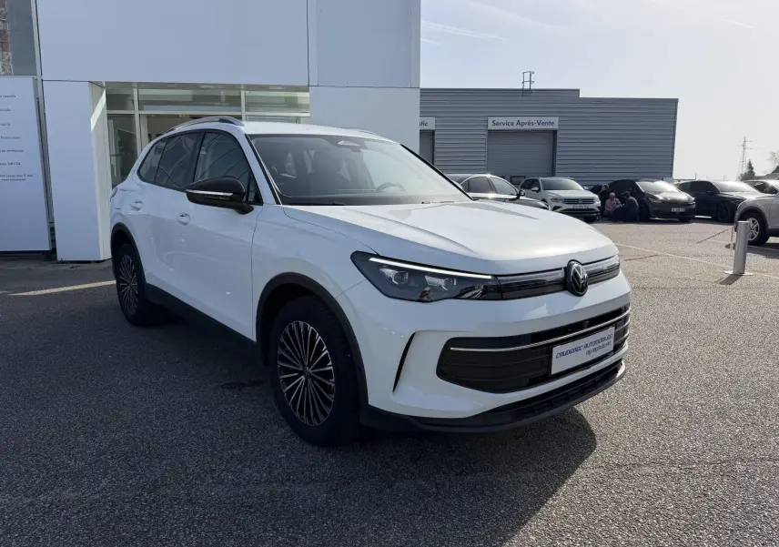Volkswagen Tiguan blanc vu en 3/4 avant droit, avec jantes alliage noir brillant et calandre moderne.