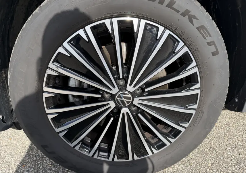 Gros plan sur la jante alliage noir brillant Napoli 18 pouces du Volkswagen Tiguan blanc de 2025.