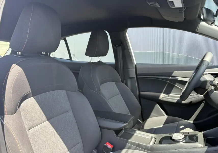 Vue intérieure côté droit des sièges tissu noir avec accoudoir central et volant du MG3 1.5 Hybrid+ 2025.