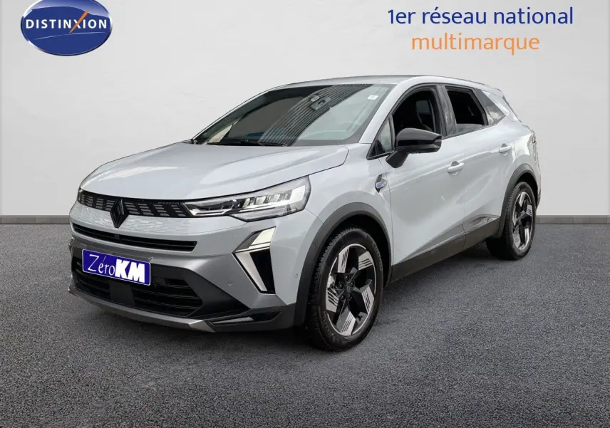 Renault Symbioz gris Rafale métal en 3/4 avant droit, SUV hybride avec calandre noire et jantes bicolores distinctives.