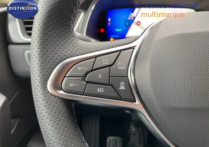 Gros plan sur les commandes du volant en cuir perforé gris du Renault Symbioz 2026, affichage numérique en arrière-plan.