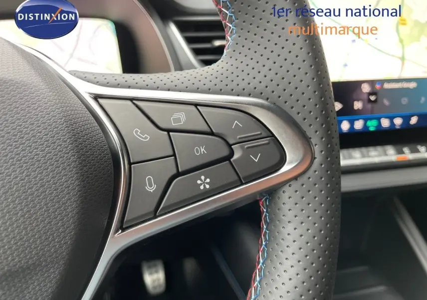 Gros plan sur les commandes au volant en cuir perforé gris avec surpiqûres tricolores du Renault Symbioz 2026.