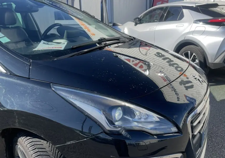 Peugeot 3008 noir vue 3/4 avant droit, mettant en valeur ses phares bi-Xénon et la calandre distinctive.