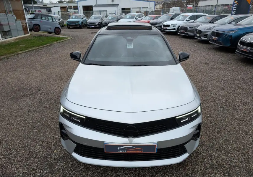 Vue avant d'une Opel Astra 2024 gris métallisé avec toit noir et calandre noire sportive.