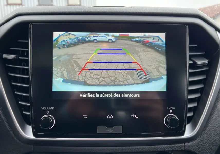 Écran central montrant la caméra de recul du pick-up Isuzu D-MAX blanc, avec lignes de guidage colorées.