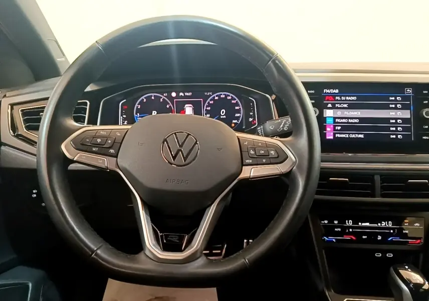 Vue intérieure centrée sur le volant cuir noir et le tableau de bord digital du Volkswagen Taigo 1.5 TSI R-Line 2023.