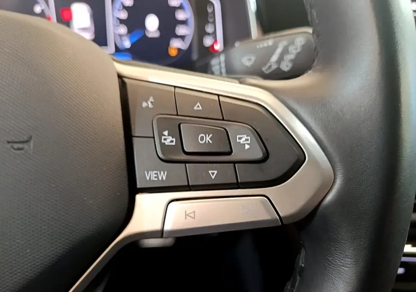 Gros plan sur les commandes gauche du volant cuir noir du Volkswagen Taigo 1.5 TSI 150 DSG R-Line 2023.