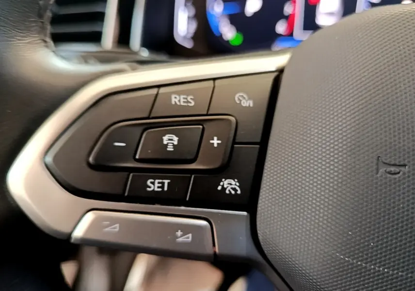 Gros plan sur les commandes multifonctions du volant cuir alu du Volkswagen Taigo noir 2023, version R-Line.