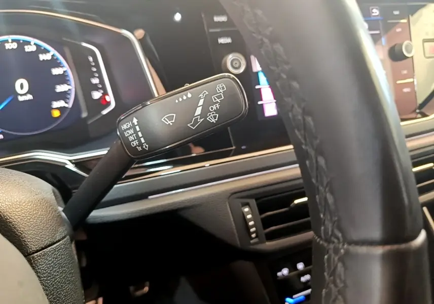 Gros plan sur la manette d’essuie-glace côté gauche du tableau de bord du Volkswagen Taigo noir 2023.