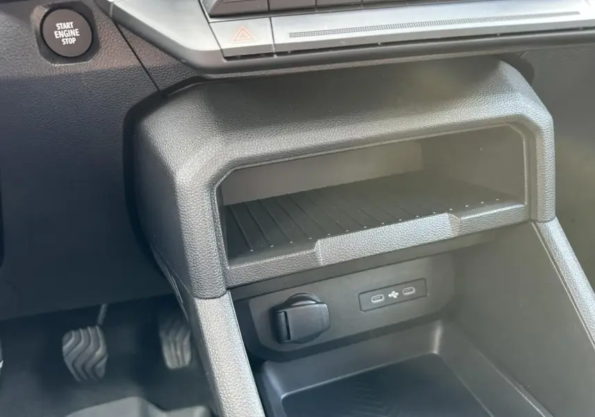Détail de la console centrale noire du Dacia Duster 2025, montrant la prise USB et le bouton Start Engine Stop.