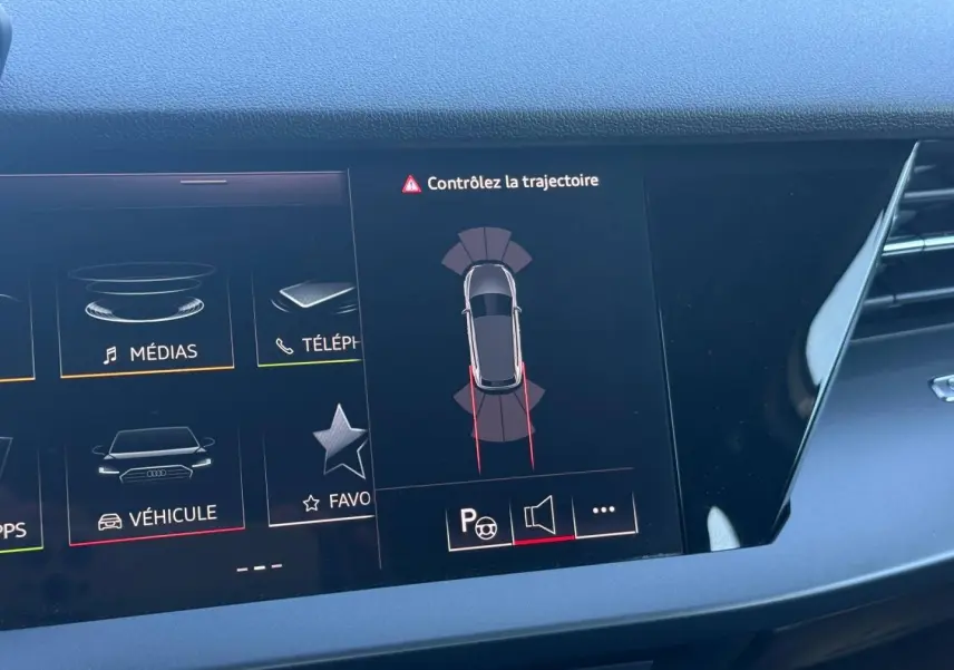 Écran central de l'Audi A3 Sportback 2024 affichant l'alerte de trajectoire et le menu véhicule, intérieur noir.
