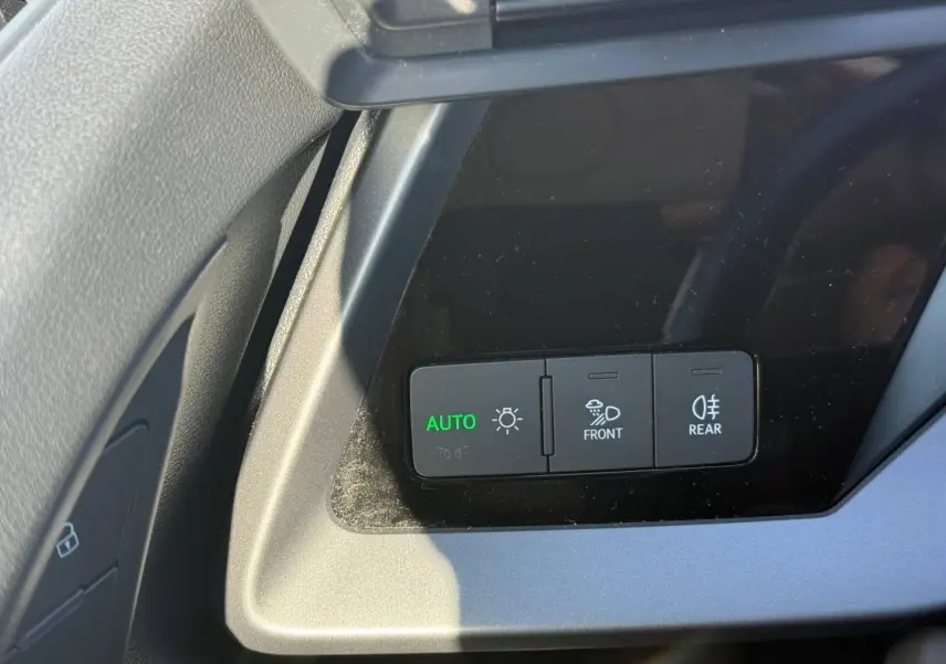 Gros plan sur les commandes d’éclairage à gauche du volant dans l’Audi A3 Sportback 2024, finition Design.
