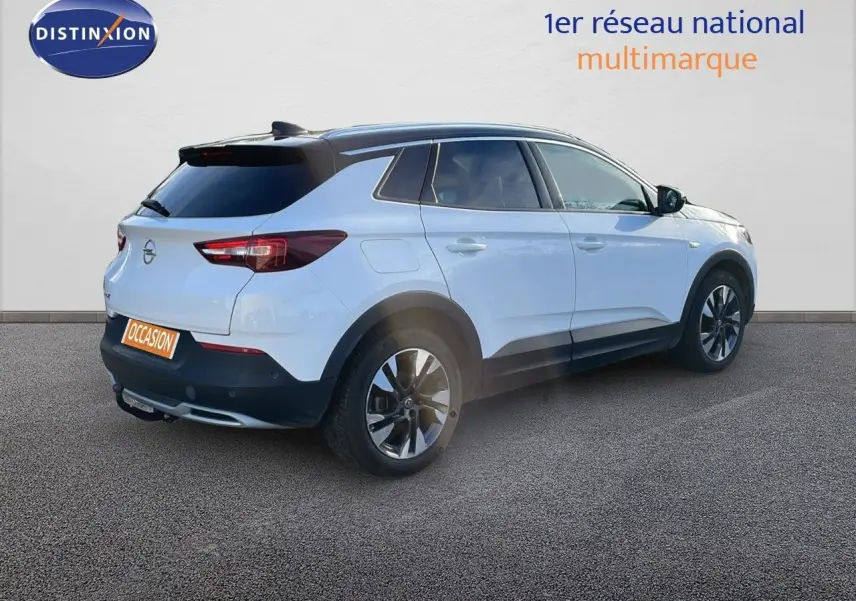 Opel Grandland X blanc toit noir en 3/4 arrière droit, mettant en valeur ses jantes et son hayon fermé.
