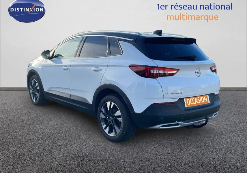 Opel Grandland X blanc toit noir en 3/4 arrière droit, SUV compact avec jantes alliage et hayon fermé.