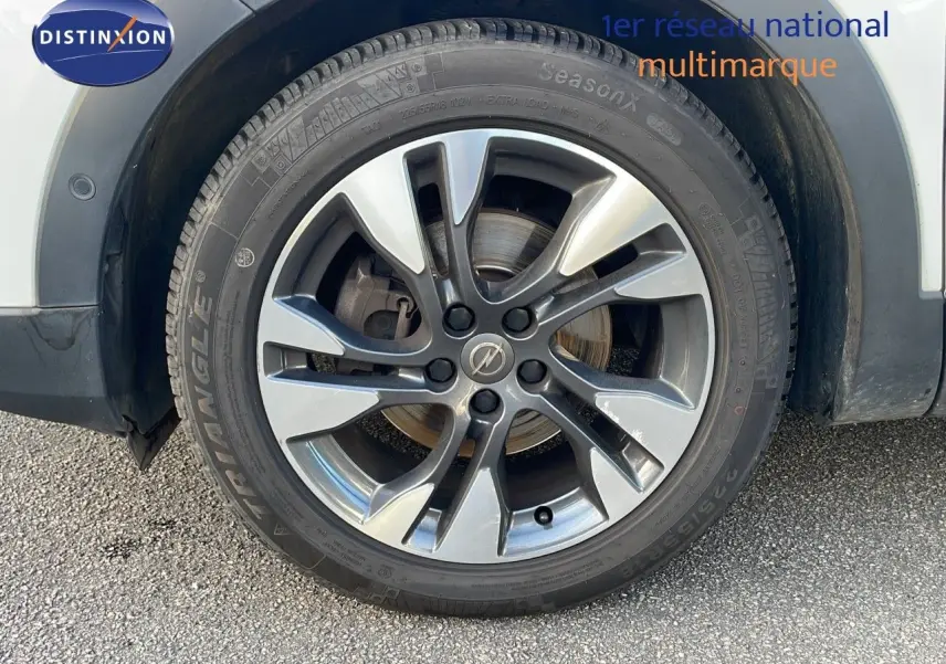 Gros plan sur la jante alliage grise du côté avant droit d'un Opel Grandland X blanc toit noir.