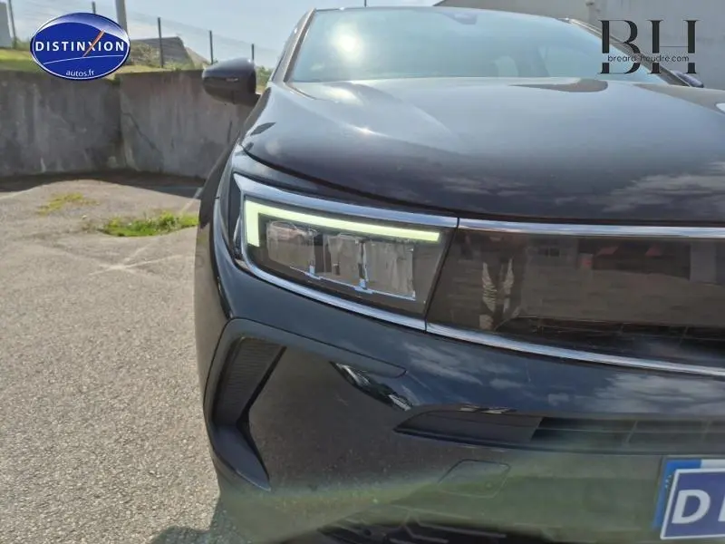 Gros plan sur le phare avant gauche du SUV Opel Grandland noir Karbon métallisé 2023, soulignant son design moderne.