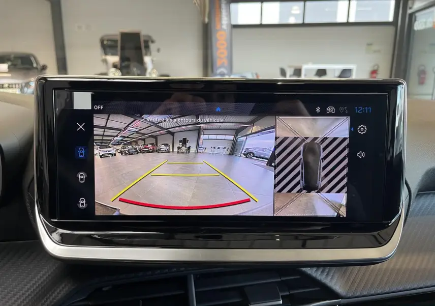 Écran tactile intérieur montrant la caméra de recul et la vue 360° du Peugeot 208 hybride blanc Okenite.