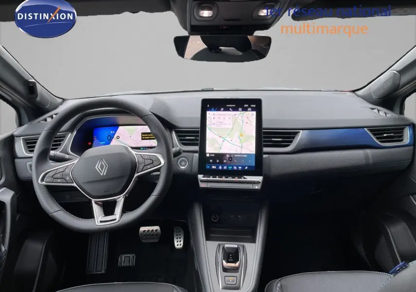 Vue intérieure avant du Renault Symbioz gris Rafale Métal, tableau de bord avec écran tactile vertical et volant multifonction.