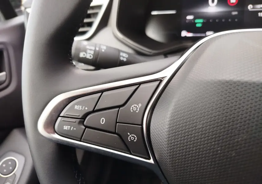 Gros plan sur les commandes de régulateur de vitesse au volant noir de la Renault Clio TCE 90CH X-TRONIC Evolution rouge flamme.