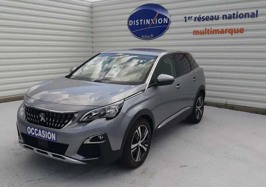 Peugeot 3008 gris vue 3/4 avant droit, avec calandre distinctive et jantes alliage bicolores.