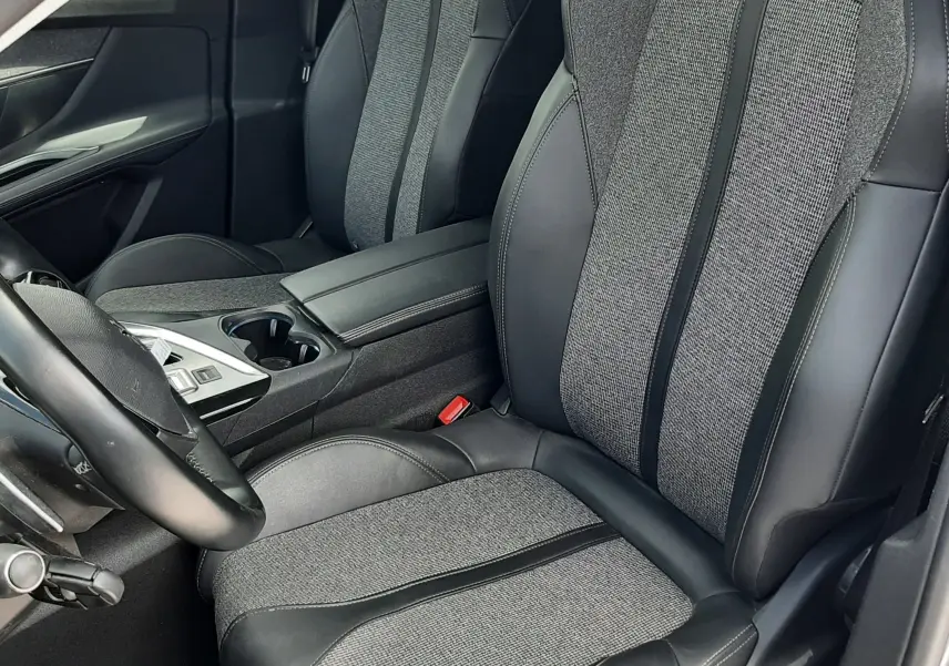 Vue intérieure rapprochée des sièges avant gris et noir en tissu et cuir du Peugeot 3008 2020 côté conducteur.