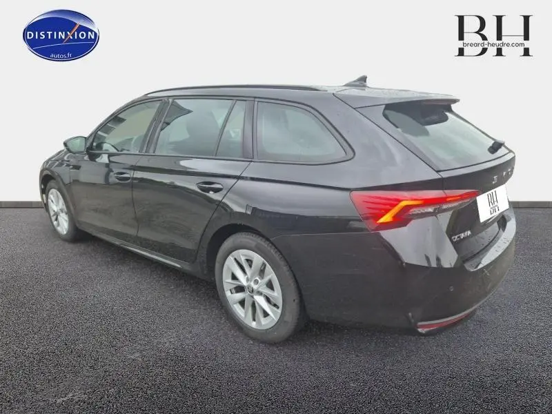 Vue 3/4 arrière droite d'une Skoda Octavia Combi noire nacrée avec feux arrière LED et jantes alu argentées.