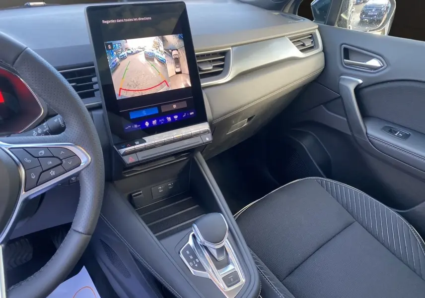 Intérieur avant droit de la Renault SYMBIOZ noir étoile 2025, avec écran tactile affichant la caméra de recul et boîte auto.