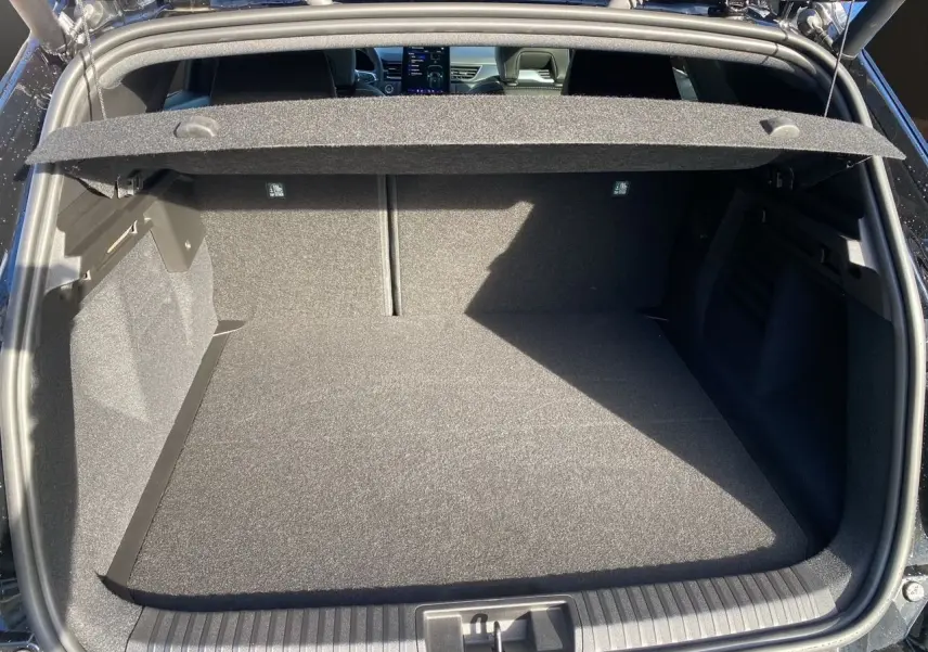 Coffre ouvert vu de l'arrière d'une Renault Symbioz noir étoile, montrant l'espace de chargement et la tablette cache-bagages.